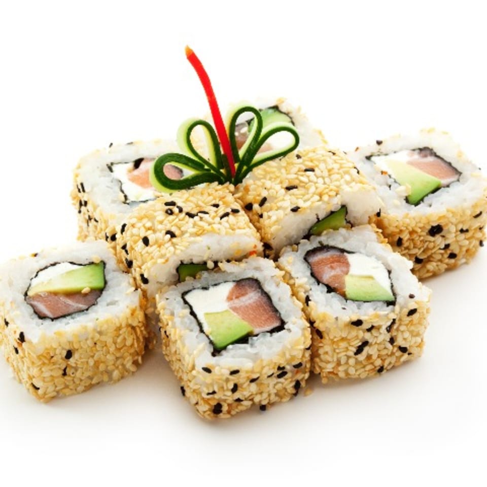 Sesame seed-crusted sushi rolls with salmon, avocado, and cream cheese, garnished with cucumber and pepper.
