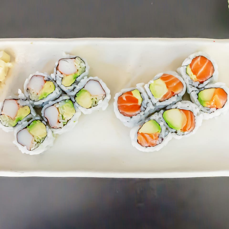 Two rows of Koiso Japanese Restaurant sushi rolls, one with crab and avocado, the other with salmon and avocado.